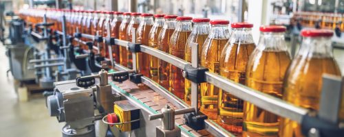 Conveyor belt, juice in glass bottles on beverage plant or factory interior, industrial manufacturing production line Conveyor belt, juice in glass bottles on beverage plant or factory interior, industrial manufacturing production line, toned